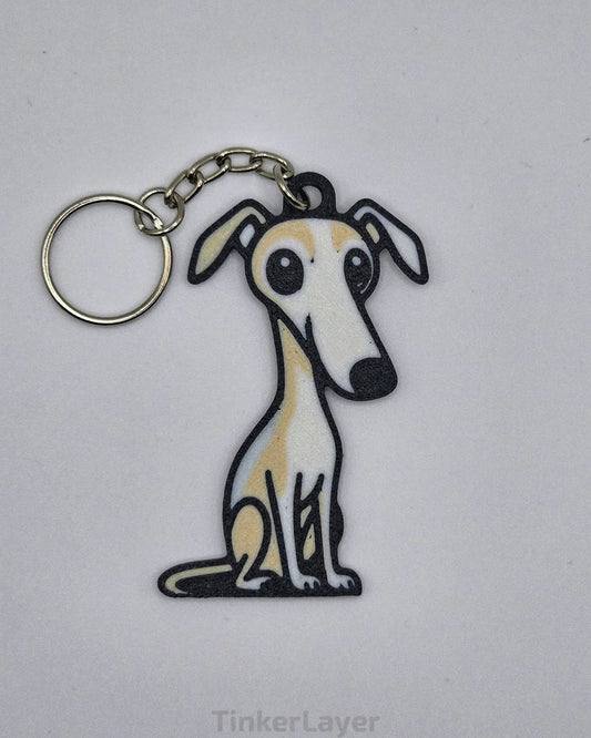 Chibi-style Whippet Greyhound keychain in a beige and white coat color on a white background