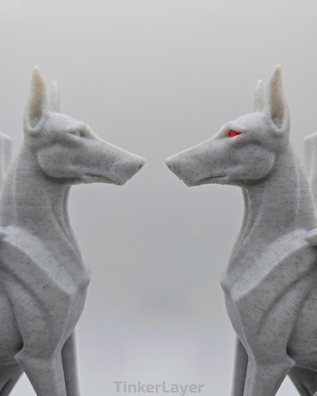 Two gothic Doberman gargoyle statues displayed face to face in marble and multicolor PLA