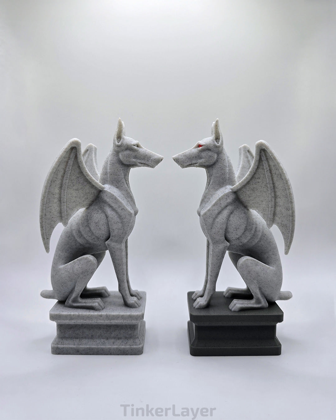 Two gothic Doberman gargoyle statues displayed face to face in marble and multicolor PLA